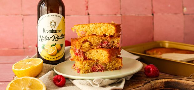 Vier aufeinandergestapelte Zitronen-Himbeer-Blondies auf einem Teller.