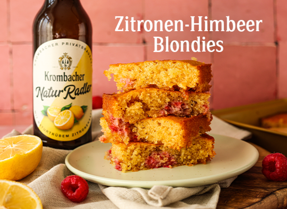 Vier aufeinandergestapelte Zitronen-Himbeer-Blondies auf einem Teller.