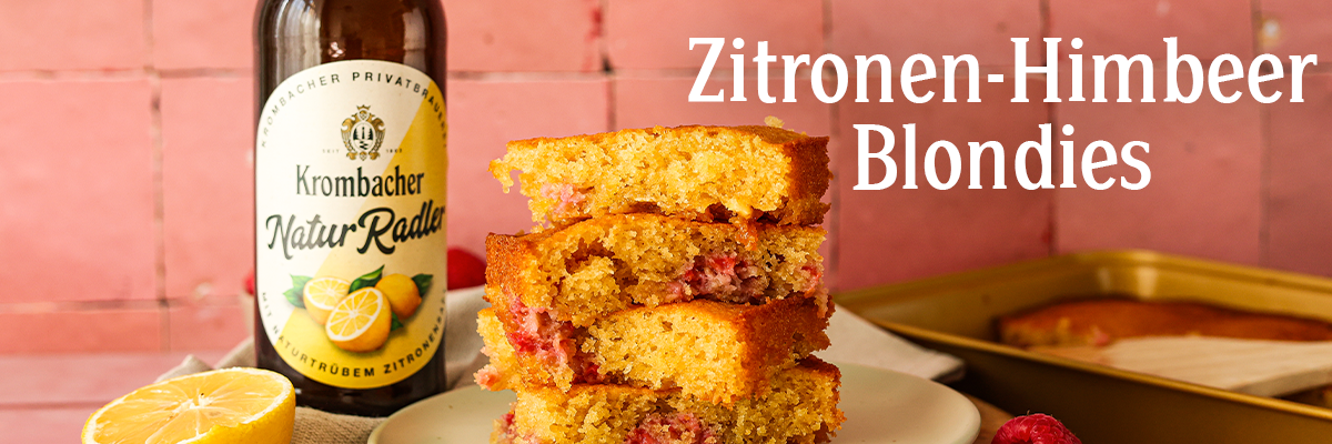 Vier aufeinandergestapelte Zitronen-Himbeer-Blondies auf einem Teller.