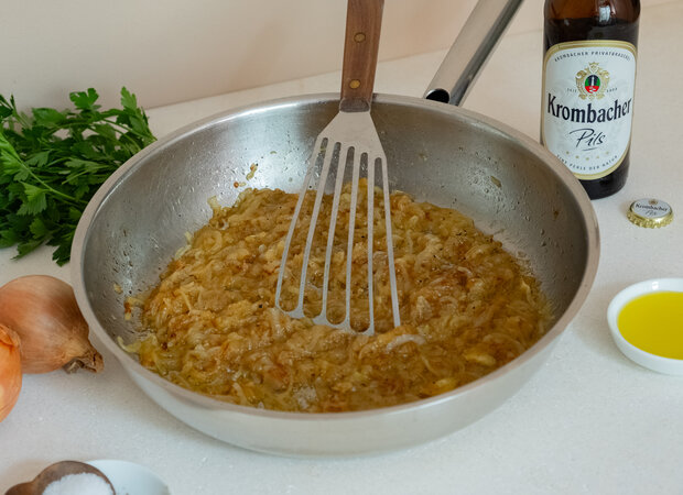Zwiebeln werden in einer Pfanne angebraten.