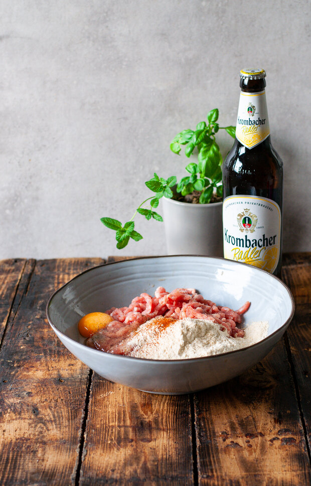 Das Hackfleisch wird in einer Schüssel zu Fleischbällchen geformt.