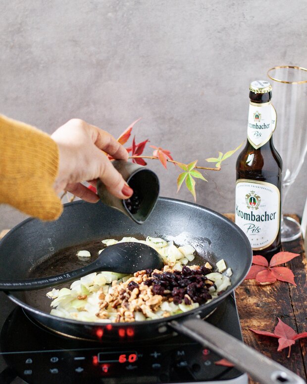 In einer Pfanne werden Cranberries, Walnüsse und Thymian mit Olivenöl geröstet.