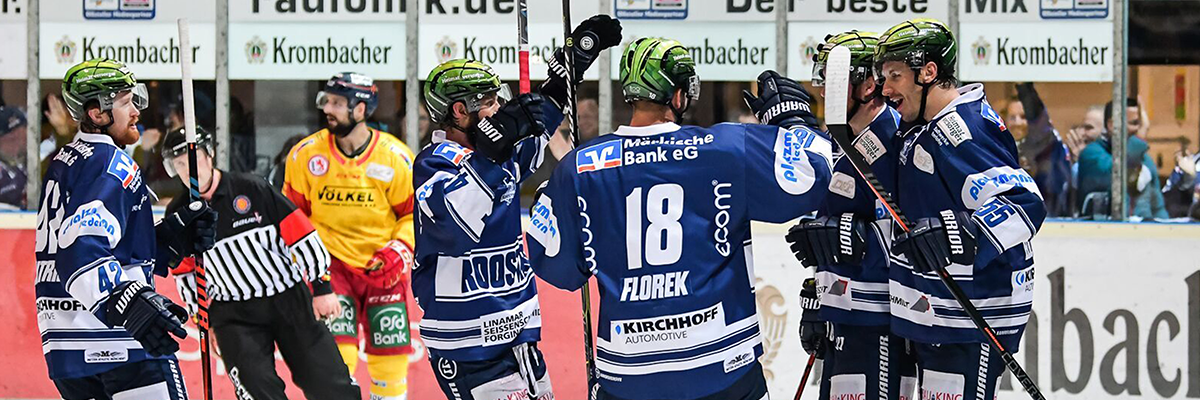 Eine Eishockeymannschaft feiert den Torerfolg.