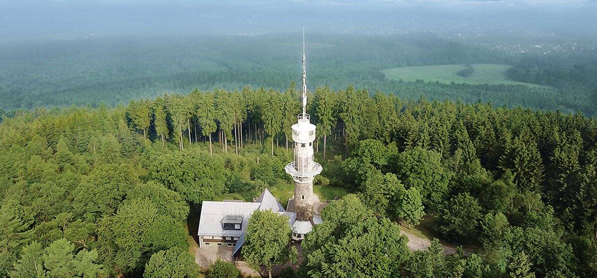 Luftaufnahme vom Kindelsbergturm in Kreuztal, umgeben von dichtem Wald.
