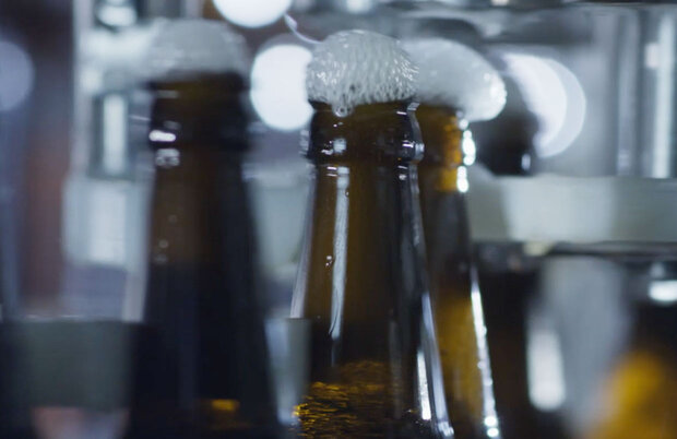 Flaschenhalt aus dem Schaum fließt.