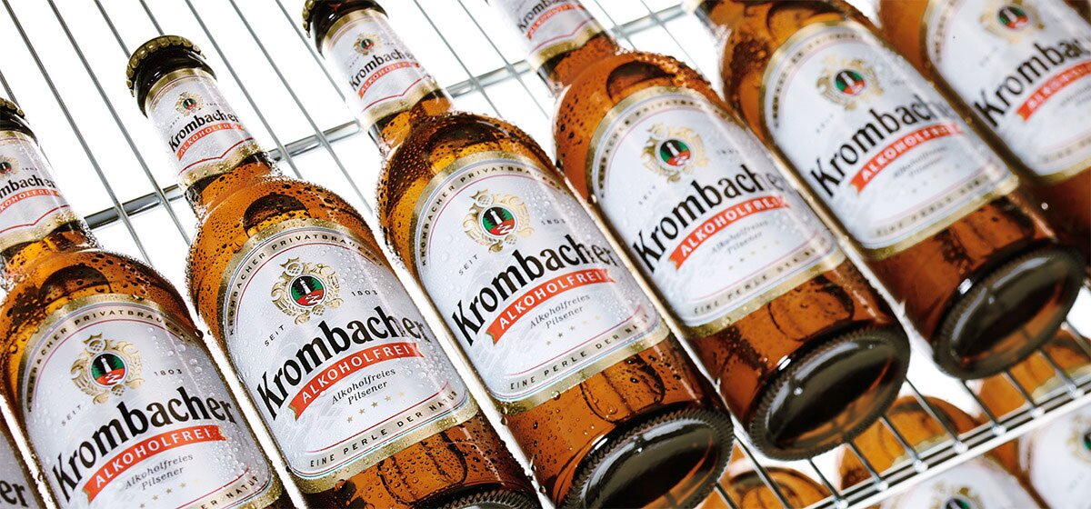 Nahaufnahme von Krombacher Pils Alkoholfrei Flaschen in einem Kühlschrank.