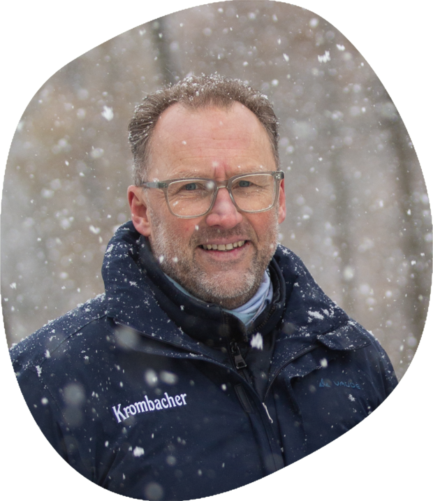 Das Bild zeigt Wolfgang Schötz, Leiter des Nachhaltigkeitsmanagements. Er hat dunkel blonde Haare und eine Brille, dazu trägt er eine dunkle Krombacher-Jacke.