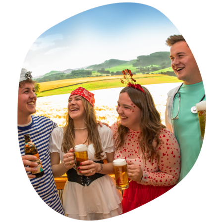 Gruppe von zwei Frauen und zwei Männern mit Krombacher Produkt in der Hand die miteinander lachen.
