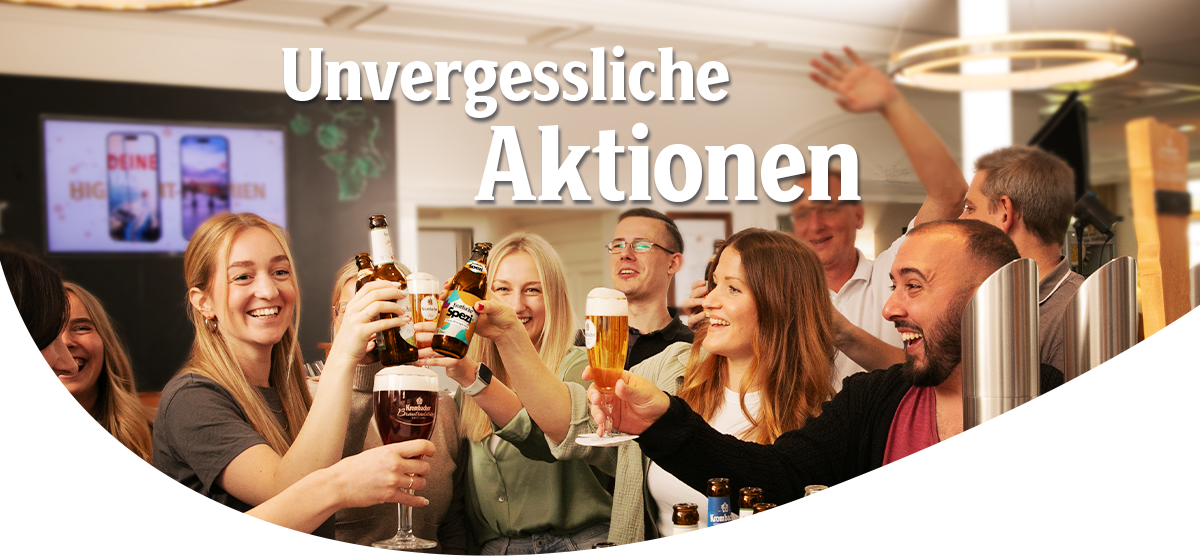 Gruppe von acht Personen stößt mit Biergläsern und Bierflaschen in in der Krombacher Erlebniswelt an unter dem Text "Unvergessliche Aktionen"