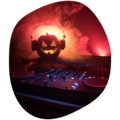 Leuchtender Halloween-Kürbis mit Kopfhörern auf DJ-Pult, rotes Bühnenlicht und Nebel im Hintergrund