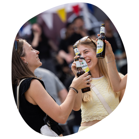 Drei Frauen stoßen mit Krombacher Radler Flaschen beim Sommerfest an