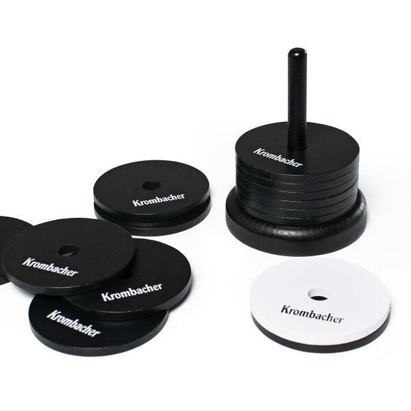 Krombacher Schockbesteck mit schwarzen und einem weißen Plättchen, auf einem Ständer gestapelt und einige vor dem Stapel verteilt.