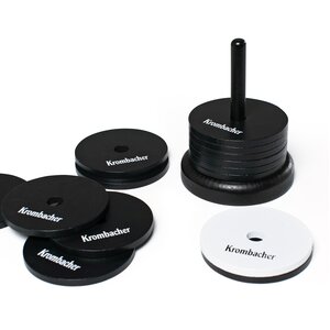 Krombacher Schockbesteck mit schwarzen und einem weißen Plättchen, auf einem Ständer gestapelt und einige vor dem Stapel verteilt.