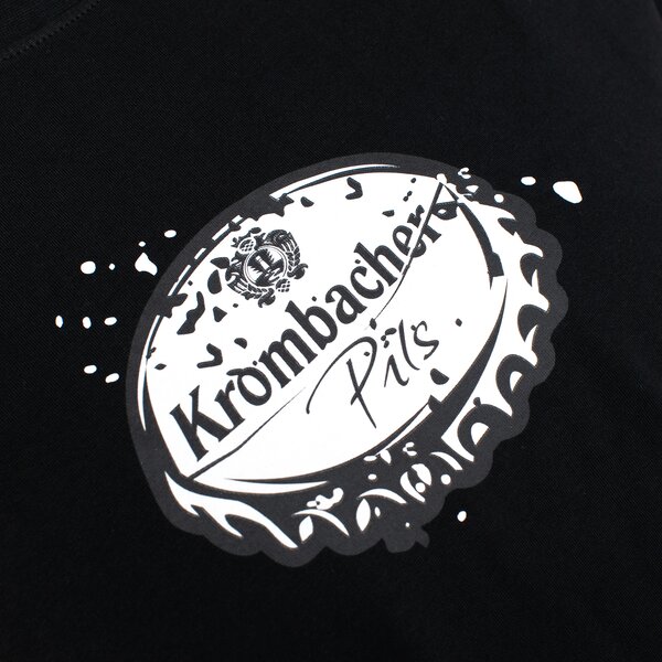 Illustrierter Kronkorken auf schwarzem Stoff.