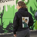 Person trägt schwarzen Hoodie mit großem Aufdruck einer Figur in grüner Uniform, die ein Bierglas hält, Rückansicht.