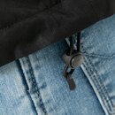 Nahaufnahme eines schwarzen Kordelzugs mit Stopper an einer schwarzen Regenjacke über blauer Jeans.