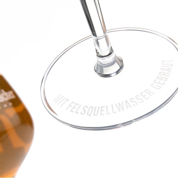 Detailaufnahme des Sockels mit der Gravur 'Mit Felsquellwasser gebraut'.