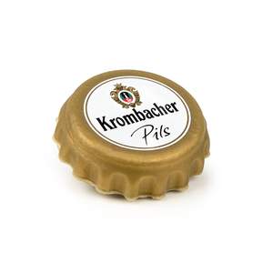 Goldener Gummiverschlusskorken mit Krombacher Pils Logo und Wappen auf weißem Hintergrund.