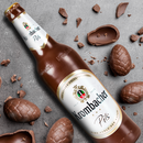 Krombacher Pils Bierflasche aus Schokolade, 0,5 Liter, mit weißem Etikett und goldenen Akzenten auf einem Tisch.