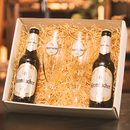 Geschenkbox mit zwei Krombacher Pils Bierflaschen und zwei passenden Biergläsern in Stroh.