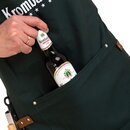 Hand steckt eine Flasche Krombacher Pils in die Tasche einer dunklen Grillschürze mit sichtbarem Krombacher-Logo
