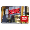Gutschein: Eingang eines REWE-Supermarkts mit rotem Schriftzug 'REWE' und Sprechblase mit Text 'REWE DEIN MARKT'