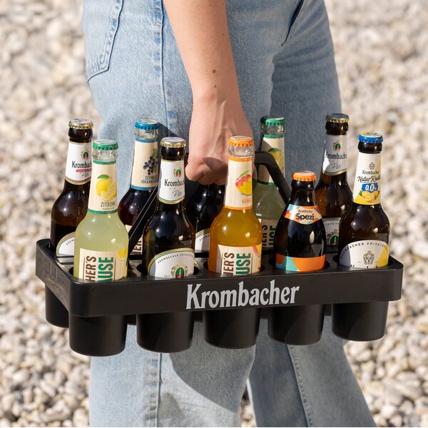 Eine Frau trägt den Krombacher Gläser-Träger, gefüllt mit Flaschen.