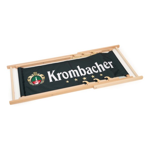 Liegestuhl zusammengefaltet mit hellbraunem Holzrahmen und dunkelgrünem Stoff mit Krombacher-Logo und fünf goldenen Sternen.