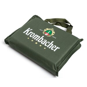 7416_krombachershop_Stadionsitzkissen_Produkt_001 Grünes, quadratisches Stadionsitzkissen mit Tragegriff und weißem Schriftzug 'Krombacher' sowie Logo.