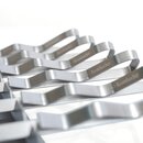 Mehrere silberne Schaschlikspieße aus Metall mit gewelltem Griff, auf denen das Wort 'Krombacher' eingraviert ist.