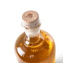 5553_krombachershop_Bierbrand_Der_Traditionelle_Produkt_002 Flasche mit goldenem Bierbrand, Holzverschluss mit Prägung und Text 'PREMIERTE QUALITÄT' und Blätter-Motiv.