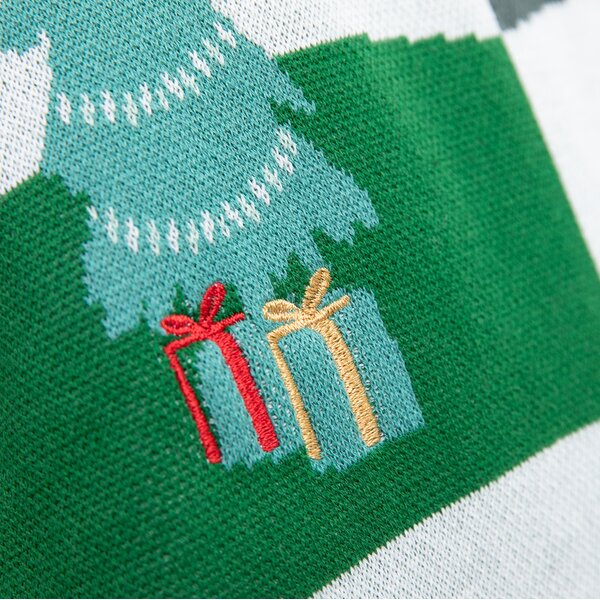 Grüner Strickstoff mit Muster eines Tannenbaums und zwei kleinen Geschenken mit Roter und gelber Schleife.