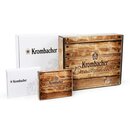 Vier Krombacher Geschenkboxen in verschiedenen Größen, zwei mit Holzoptik und Aufschrift 'Krombacher Brautradition seit 1803', zwei weiße mit Krombacher-Logo.