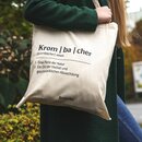 Jutebeutel mit Krombacher-Logo und Lautschrift 'Krom | ba | cher' mit Definitionen: '1. Eine Perle der Natur 2. Ein Ort der Vielfalt und geschmacklichen Abwechslung'.